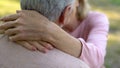 Female hands hugging husband neck, old couple kissing and embracing, mature love Royalty Free Stock Photo