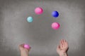 Female hands juggle colorful eggs.