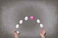 Female hands juggle colorful eggs.