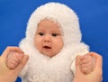 Female hands keep the baby in a New Year's suit of the Snowflake