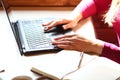 Female hands on the keyboard type text. Notebook, pen, mobile phone, cup of coffee on a table. Breakfast business person. Morning