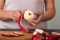 Female hands in kitchen clean and cut fresh juicy apples