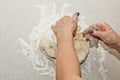 Female hands knead the dough with flour on a white kitchen table. Top view. baking preparation stage, cooking Royalty Free Stock Photo