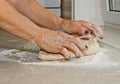 Female hands knead the dough with flour on a white kitchen table. Top view. baking preparation stage, cooking Royalty Free Stock Photo