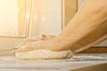 Female hands knead the dough with flour on a white kitchen table. Top view. baking preparation stage, cooking Royalty Free Stock Photo