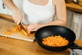 Female hands with a knife cut fresh carrots in the kitchen Royalty Free Stock Photo