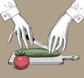 Female hands with a knife and vegetables on the wood cutting board