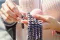 Female hands knit clothing from wool on knitting needles. Royalty Free Stock Photo
