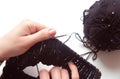 Female hands with knitting needles to knit wool sweater on white background