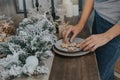 Female hands are laid out Christmas gingerbreads in the shape of snowflakes on a plate. Selective focus.