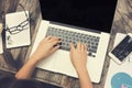 Female hands on laptop keyboard with another computer tablet on