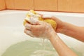 Female hands lathering yellow sponge with soap Royalty Free Stock Photo