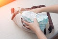 Female hands lay baby diapers in a bag, close-ups, diaper