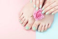 Female hands, legs with manicure and pedicure with flower on a pink, blue background, top view Royalty Free Stock Photo