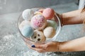 Female hands on a light background hold a bowl full of multi-colored balls for a bath, handmade Royalty Free Stock Photo