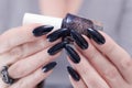 Female hands with long nails and black blue manicure Royalty Free Stock Photo