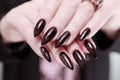 Female hands with long nails and black and red manicure Royalty Free Stock Photo