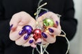 Female hands with long nails and bright purple and blue manicure hold a Christmas balls