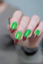 Female hands with long nails and green and brown manicure Royalty Free Stock Photo