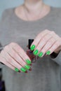 Female hands with long nails and green and brown manicure Royalty Free Stock Photo