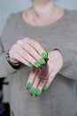 Female hands with long nails and green and brown manicure Royalty Free Stock Photo