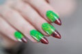 Female hands with long nails and green and brown manicure Royalty Free Stock Photo