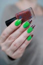 Female hands with long nails and green and brown manicure Royalty Free Stock Photo