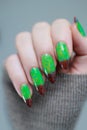 Female hands with long nails and green and brown manicure Royalty Free Stock Photo