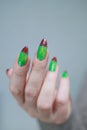 Female hands with long nails and green and brown manicure Royalty Free Stock Photo