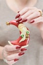 Female hands with long nails and red manicure hold a small statuette of Santa Claus Royalty Free Stock Photo