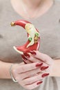 Female hands with long nails and red manicure hold a small statuette of Santa Claus Royalty Free Stock Photo