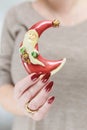 Female hands with long nails and red manicure hold a small statuette of Santa Claus Royalty Free Stock Photo