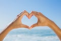 Female hands making heart shape by the sea Royalty Free Stock Photo