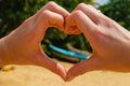 Female hands making heart shape by the sea Royalty Free Stock Photo