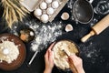 Female hands making/ mixing dough in brown bowl on black table, baking preparation close-up. Royalty Free Stock Photo