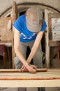 Female hands are making some marks on wooden plank for future holes using pencil for assembling bench, gender equality