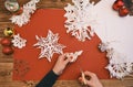Female Hands making white paper snowflakes over wooden table Royalty Free Stock Photo