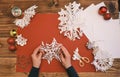 Female Hands making white paper snowflakes over wooden table Royalty Free Stock Photo