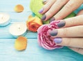 Female hands, manicure, concept flower rose, candle on a wooden background Royalty Free Stock Photo