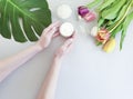 Female hands manicure healthy  beauty ,  cosmetic creative cream moisturizing , monstera tulip leaf on a background Royalty Free Stock Photo
