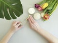 Female hands manicure healthy products beauty , cosmetic creative cream moisturizing , monstera tulip leaf on a background Royalty Free Stock Photo