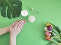 Female hands manicure healthy  beauty , spring cosmetic creative cream moisturizing , monstera tulip leaf on a background Royalty Free Stock Photo