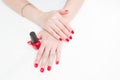 Female hands with manicure and red lacquer on a white table in the beauty salon. closeup of hand of a young woman. Royalty Free Stock Photo