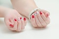 Female hands with manicure, red nail polish, drawing with cherries. White background