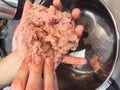 female hands mixing minced meat and make meatballs