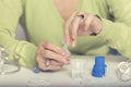 Female hands opening ampule with drug for nebulizer.