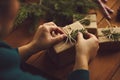 Female hands packing Christmas gifts on table