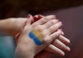 Female hands painted in Ukraine flag colors yellow-blue. Stop the war and the power of Ukraine, patriotism and Kiev, strength and