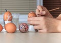 Female hands painting colorful Easter eggs at table