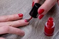 Female hands painting red nail varnish Royalty Free Stock Photo